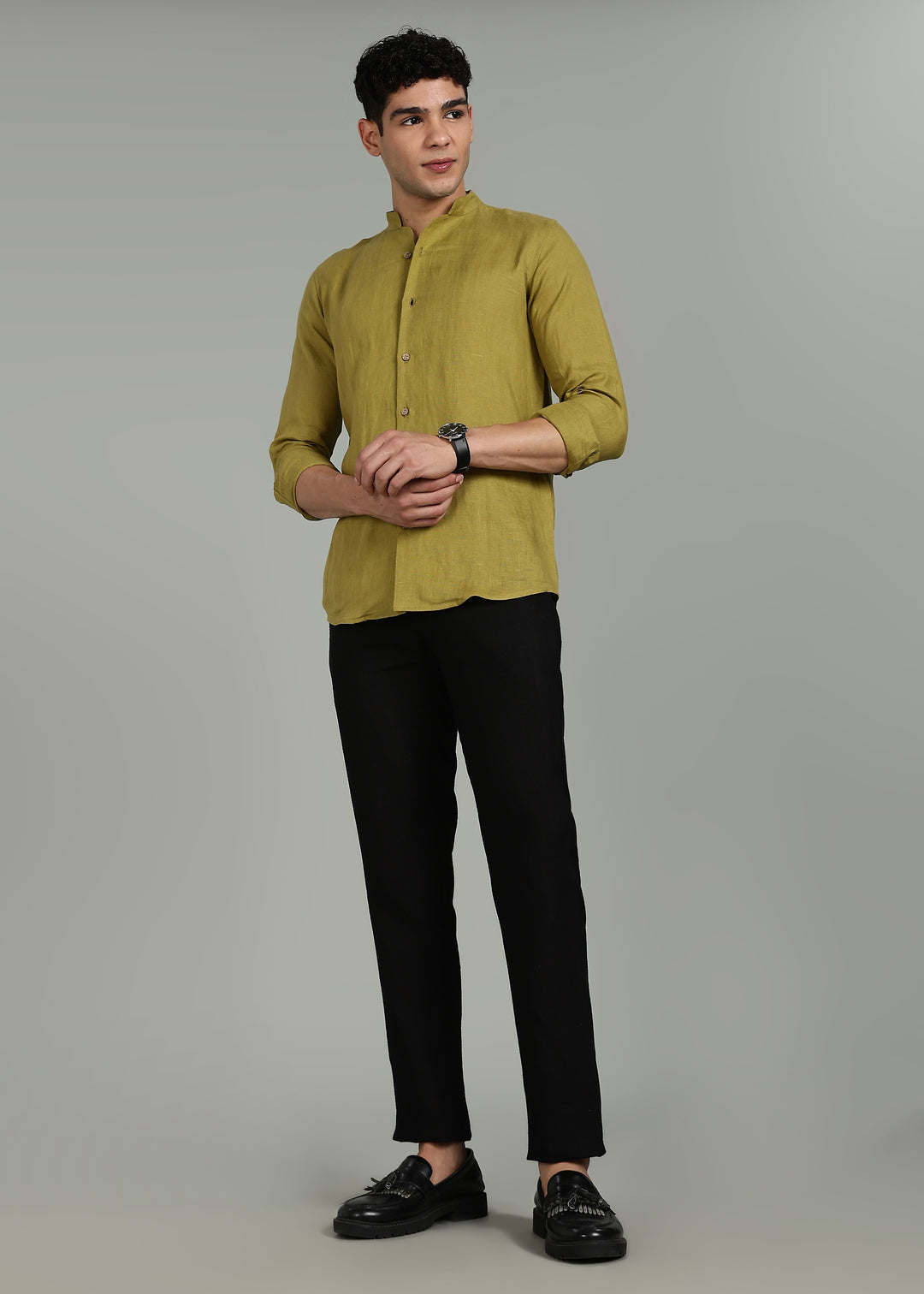 Man wearing 100% pure linen sap green full sleeve shirt in 60 LEA and black pants on a gray background