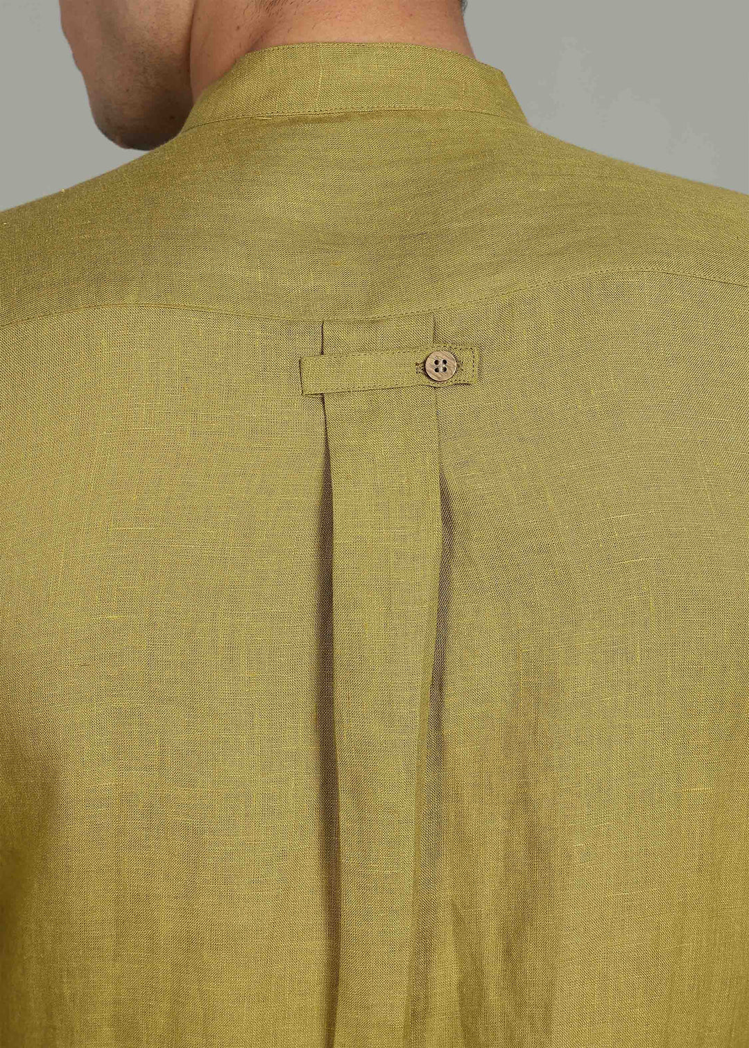 Close-up of a 100% pure linen sap green full sleeve shirt in 60 LEA with a button on a gray background